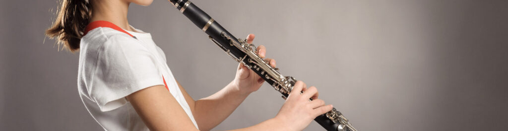 a girl playing a clarinet in side profile