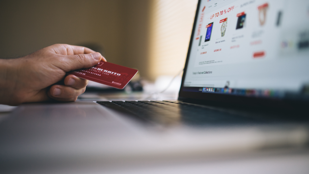 person holds a card while shopping online. stay safe online by being careful what sites you use.
