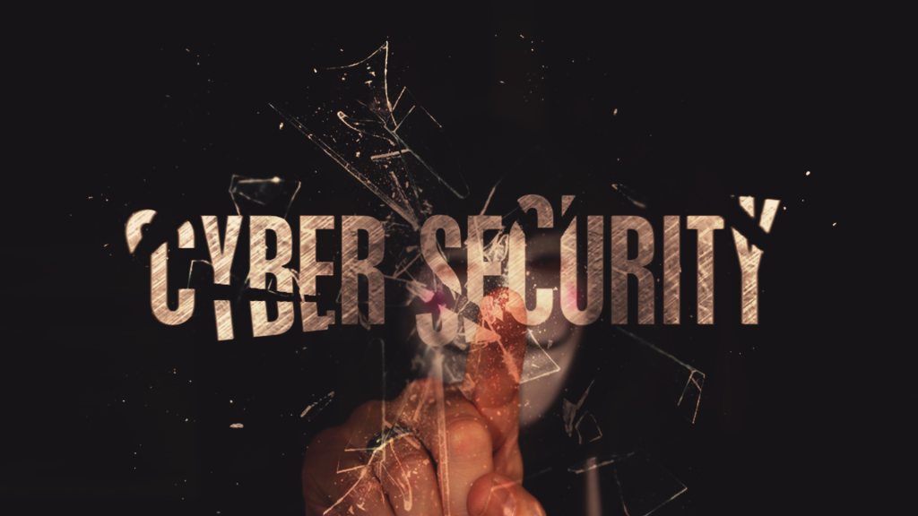 Image of the word cyber security falling to pieces with a hacker touching it. Ransomware is a big threat to SMBs.